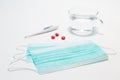 Medical protective face mask, three red tablets, electronic thermometer for measuring body temperature on a white background.