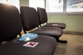 Medical protective mask that is left lying on chair in public place after used,social distancing paper sign with garbage of face