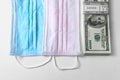 Medical protective masks and and a bundle of dollars, money on white background. Chinese coronavirus covid-19 outbreak concept. Royalty Free Stock Photo