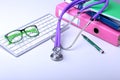 Medical record concept with stethoscope over pile of folders. Keyboard, glasses, pen, RX prescription. Selective focus Royalty Free Stock Photo