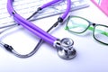 Medical record concept with stethoscope over pile of folders. Keyboard, glasses, pen, RX prescription. Selective focus Royalty Free Stock Photo