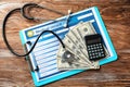 Medical record with stethoscope, money and calculator on table. Health care concept