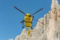 Medical rescue helicopter flying rescue injured climber on the Tre Cime. Italy, Dolomites