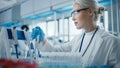 Medical Research Laboratory: Portrait of a Beautiful Female Scientist in Goggles Using Micro Pipet Royalty Free Stock Photo