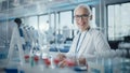 Medical Research Laboratory: Portrait of a Beautiful Female Scientist Writing Down Data, Smiling o Royalty Free Stock Photo