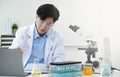 Medical Research Laboratory: Portrait of a Handsome Male Scientist Using Digital Tablet Computer, Analysing Liquid Royalty Free Stock Photo