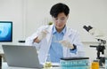 Medical Research Laboratory: Portrait of a Handsome Male Scientist Using Digital Tablet Computer, Analysing Liquid Royalty Free Stock Photo