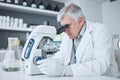 Medical, research or man with a microscope, laboratory or science with a breakthrough, review and check sample. Male Royalty Free Stock Photo