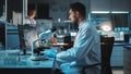 Medical Research Scientist Conducts DNA Experiments Under a Microscope and Writes Results on Deskt Royalty Free Stock Photo