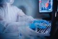 Medical research scientist work online computer blood test on slide in modern laboratory. Blue color, virus epidemic
