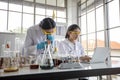 Medical Research and Scientists are working with a microscope and a tablet and Test Tubes, Micropipette and Analysis Result in a Royalty Free Stock Photo