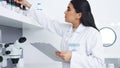 Medical researcher checking bottles with chemicals inside a modern science lab. Young focused scientist or pharmacist