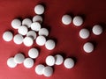 Medical round white tablets, calcium vitamins closeup on red background with space for text or image. Pills.