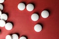 Medical round white tablets, calcium vitamins closeup on red background with space for text or image. Pills.