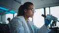 Medical Science Laboratory: Beautiful Black Scientist is Using Microscope, Doing Analysis of Test Royalty Free Stock Photo