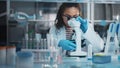 Medical Science Laboratory: Portrait of Beautiful Black Scientist Looking Under Microscope Does Royalty Free Stock Photo