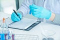 Medical science or male Compiling an Analysis Report in laboratory room research performs tests with blue liquid on test tube, Royalty Free Stock Photo