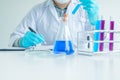 Medical science or male Compiling an Analysis Report in laboratory room research performs tests with blue liquid on test tube,