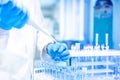 Medical Scientist and chemist in laboratory using an pipette or dropper for liquid samples