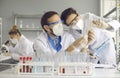Medical scientists who are doing research in laboratory are looking at two glass tubes Royalty Free Stock Photo