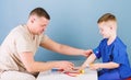 Medical service. Man doctor sit table medical tools examining little boy patient. Health care. Pediatrician concept Royalty Free Stock Photo
