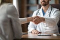 Medical Services Concept. Doctor And Female Patient Handshaking During Meeting In Clinic Royalty Free Stock Photo