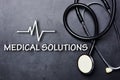 Medical solutions text on blackboard with stethoscope and heartbeat rate Royalty Free Stock Photo