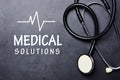 Medical solutions text on blackboard with stethoscope and heartbeat rate Royalty Free Stock Photo