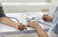 Senior patient with hypertension gets blood pressure checked during checkup at hospital