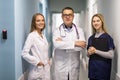 Medical staff discussing in clinic hallway. Healthcare professionals having discussion in hospital corridor Royalty Free Stock Photo