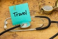 Medical stethoscope, compass and a card with the words `Travel` on the background of an old map of the world, The concept of safe Royalty Free Stock Photo