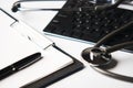 Medical stethoscope on computer keyboard with clipboard and pen Royalty Free Stock Photo