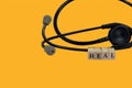 Medical stethoscope and headphones with the word "heal" spelled out in alphabet blocks Royalty Free Stock Photo