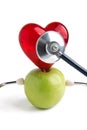 Medical stethoscope and heart on green apple isolated on white background Royalty Free Stock Photo