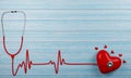 Medical stethoscope and Heart pulse red On the blue plank floor. Small and large red heart shaped models. 3D Rendering