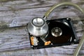 A medical stethoscope on a laptop 2.5 inch hard disk drive storage memory, repair broken computer part, an open hard disc with Royalty Free Stock Photo