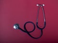 Medical stethoscope or phonendoscope  isolated on red background. Close-up of a stethoscope. flat lay. Royalty Free Stock Photo