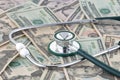 Medical stethoscope on a pile of money signifying the relationship of money and medicine Royalty Free Stock Photo