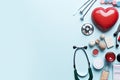 Medical stethoscope, pills and red heart on blue background, Many different medical objects on light background top view, AI
