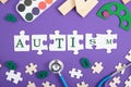 Medical stethoscope, puzzles, dominoes, paints, glasses, educational toys on a purple background top view, the inscription autism Royalty Free Stock Photo