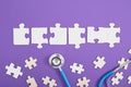 medical stethoscope, puzzles, dominoes, paints, glasses, educational toys on a purple background top view, the Royalty Free Stock Photo