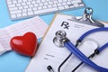 Medical stethoscope and red heart lying on cardiogram chart closeup. Medical help, prophylaxis, disease prevention or Royalty Free Stock Photo