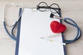 Medical stethoscope and a red heart and tablet placed on a document on white background Royalty Free Stock Photo