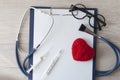 Medical stethoscope and a red heart and tablet placed on a document on white background Royalty Free Stock Photo