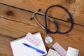 Medical stethoscope and tablets isolated on wooden background Royalty Free Stock Photo