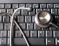 Medical stethoscope on top of laptop computer keyboard