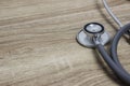 A medical stethoscope on a wooden table.