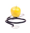 Medical stethoscope and yellow apples.