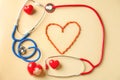 Medical stethoscopes, pills and red hearts on light background. Cardiology concept