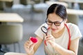 Medical student holding a magnifying glass and looks at a yarn red heart on blurred background. Royalty Free Stock Photo